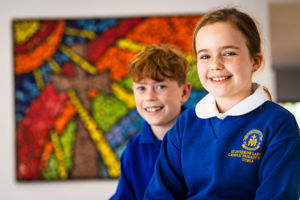 Students at St Catherine Laboure Catholic Primary School Gymea smiling in front of mural