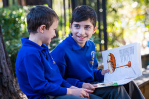 Olde student at St Catherine Labouré Catholic Primary School Gymea reading to younger student