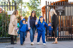 Parent walking her children into the school grounds at St Catherine Labouré Catholic Primary School Gymea